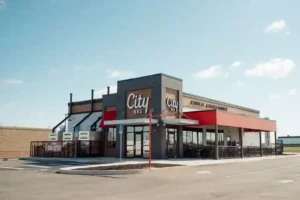 City BBQ restaurant with red awning, outdoor seating, and modern smokehouse design