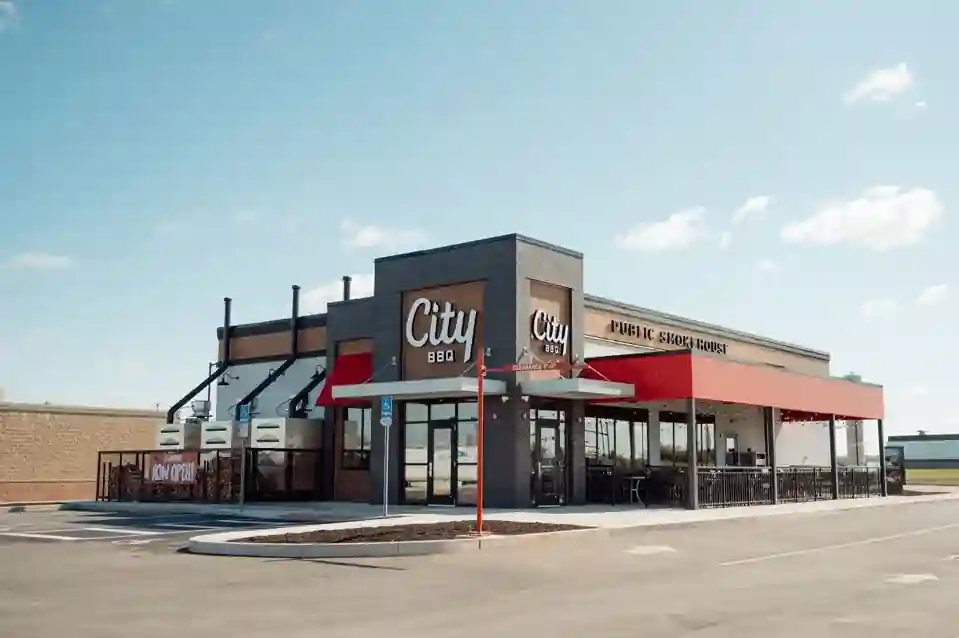 City BBQ restaurant with red awning, outdoor seating, and modern smokehouse design
