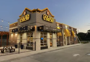 Golden Chick restaurant exterior at dusk with lights and yellow signage.