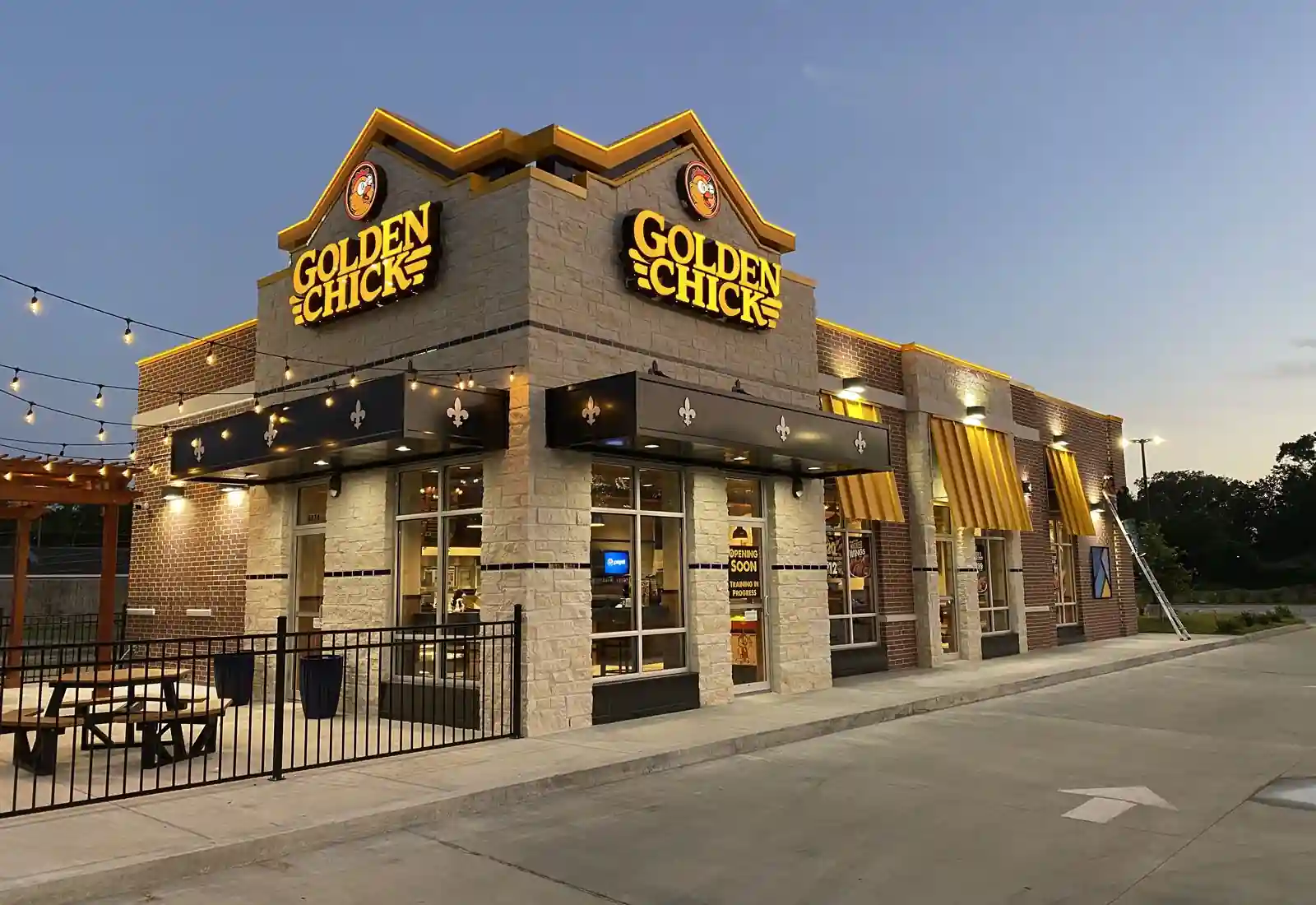 Golden Chick restaurant exterior at dusk with lights and yellow signage.