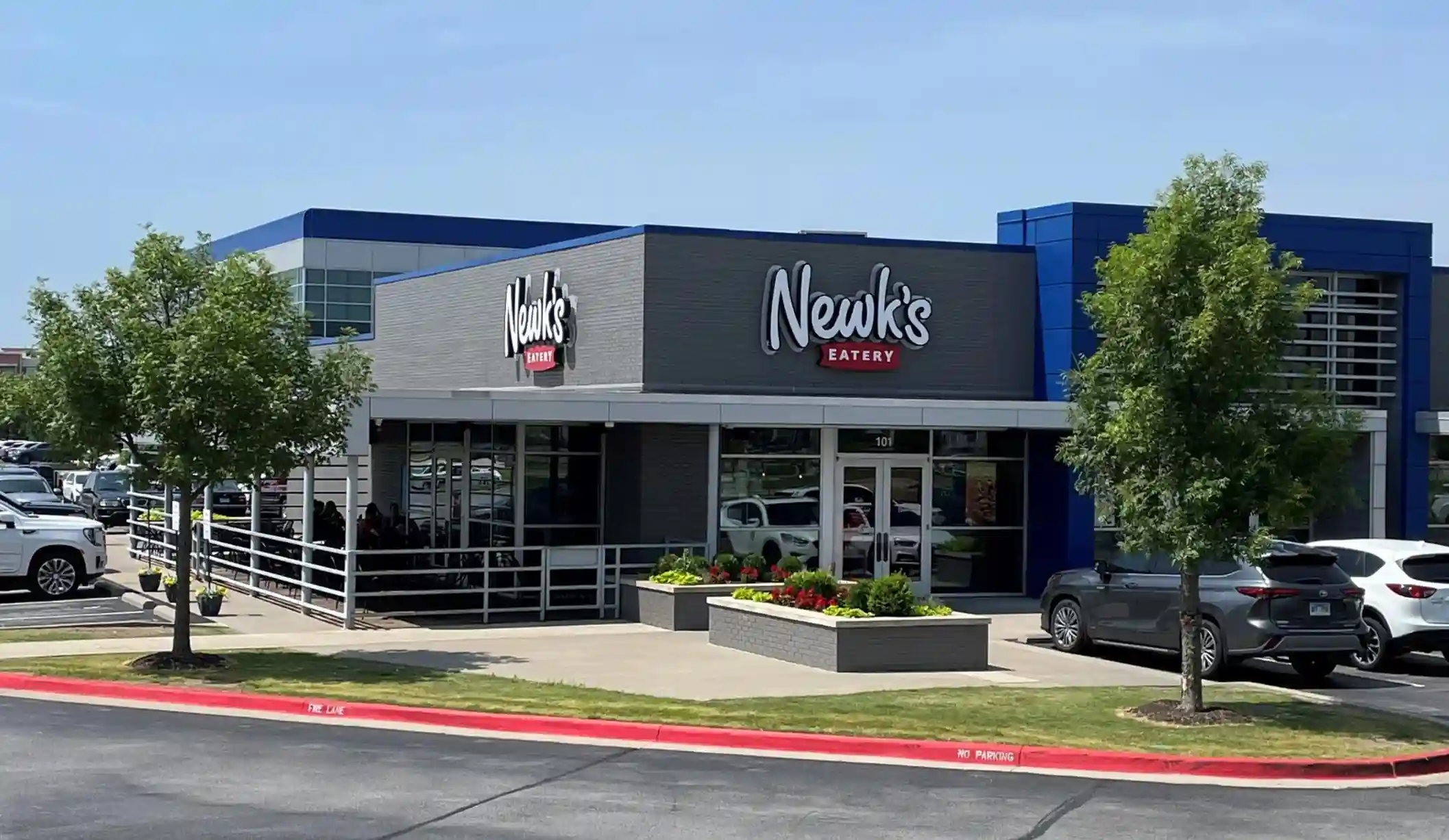 Exterior view of Newk's Eatery restaurant with modern building design and outdoor seating.