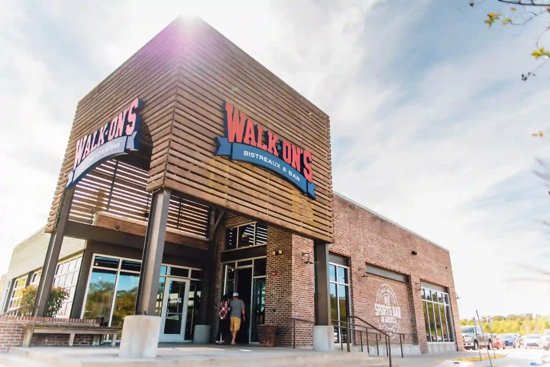 Exterior of Walk-On's Bistreaux & Bar restaurant, featuring a modern brick and wooden design with bold signage.