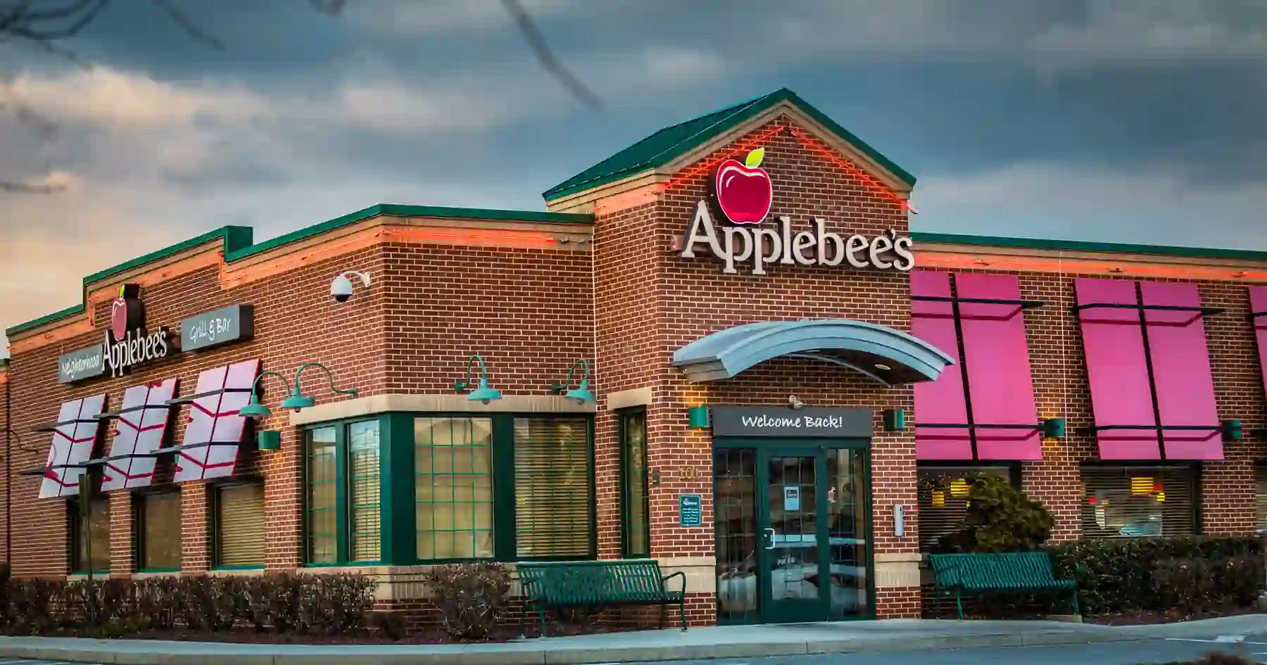 Exterior of an Applebee’s restaurant with red brick walls, green trim, and welcoming signage.