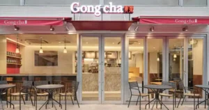 Gong Cha storefront with red awnings and outdoor tables and chairs